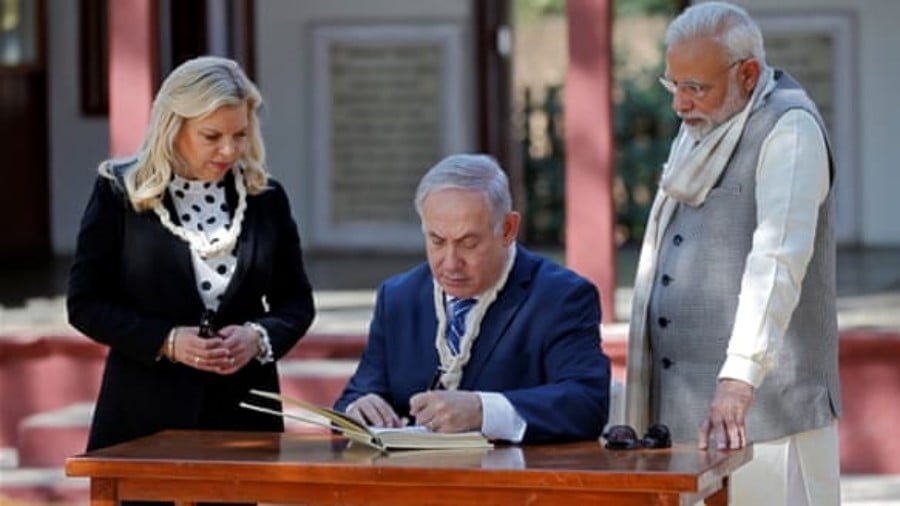 Israeli Prime Minister Benjamin Netanyahu writes a message in the visitor's book at Gandhi Ashram in Ahmedabad, India on January 17 [Reuters/Amit Dave]