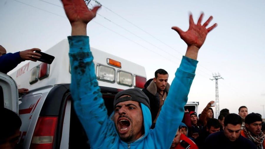 A Palestinian with blood on his hands reacts as a wounded demonstrator is evacuated during clashes with Israeli troops, near the border with Israel in the east Gaza Strip on January 19. Mohammed Salem / Reuters