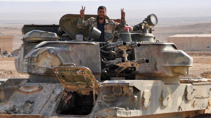 A Syrian soldier flashes a ‘V for Victory’ sign from his tank AFP
