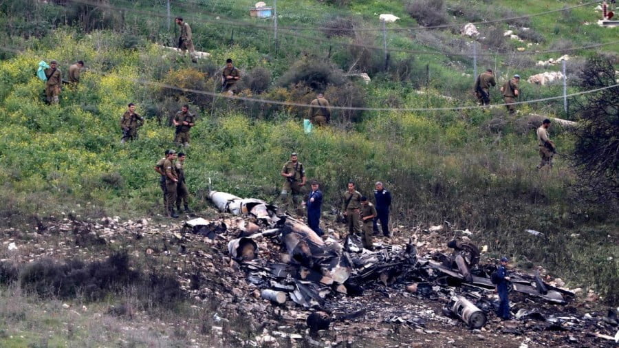 Israeli soldiers inspect the remains of an Israeli F-16 fighter jet shot down by a Syrian anti-aircraft system / EPA
