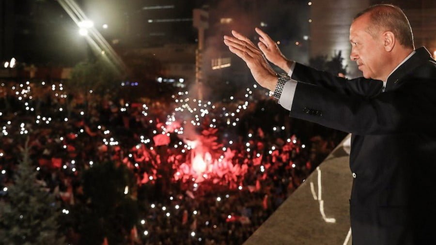 Turkish President Tayyip Erdogan waves to supporters from a balcony at the AK Party headquarters in Ankara, on June 24 as they celebrate him winning five more years in office with sweeping new powers after a decisive election victory. Photo: AFP / Turkish Presidential Press Office / Kayhan Ozer