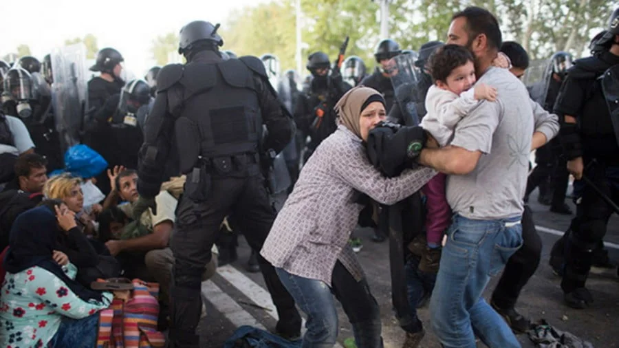 Hungarian policemen attack refugees during a protest in front a closed gate at the border with Serbia. (Photo: ActiveStills.org)