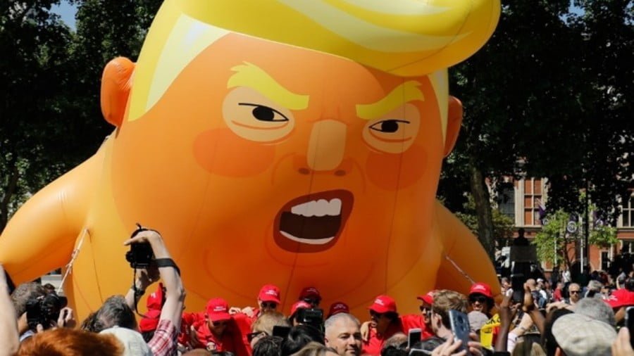 Activists inflate a giant balloon depicting US President Donald Trump during a demonstration against Trump's visit to the UK in Parliament Square in London on 13 July 2018 (AFP)