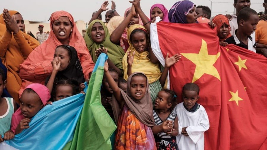 People hold Chinese and Djiboutian national flags as they wait for Djibouti's President before the opening of a 1,000-unit housing construction project in Djibouti on July 4, 2018. The project was financially supported by a Chinese company. Photo: AFP/Yasuyoshi Chiba