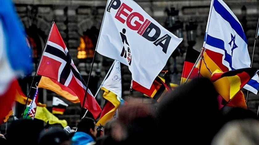Flag of Israel side-by-side with that of Pegida and other nationalist flags at a rally in Germany