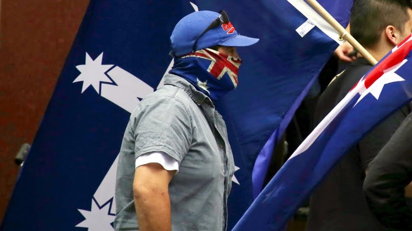 A supporter of the anti-Islam group Reclaim Australia wears a scarf displaying the Australian national flag around his face during a rally in central Sydney, Australia, 22 November 2015 (Reuters)