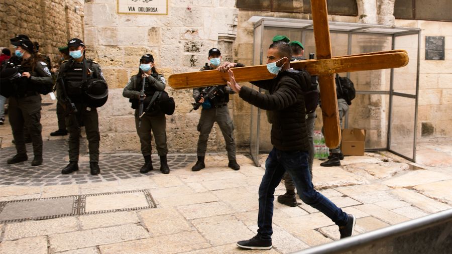 A Christian man carries a cross along the Via Dolorosa ahead of the Good Friday procession in Jerusalem’s Old City, on April 2, 2021. Maya Alleruzzo | AP